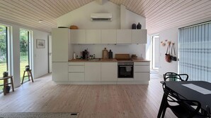 Eine moderne Küche mit weißen Schränken, einer Holz Arbeitsplatte und einem eingebauten Backofen.