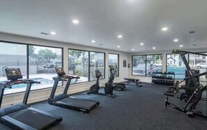Ein Fitnessstudio mit Laufbändern, Crosstrainern und Gewichten.