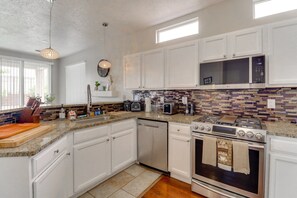 A kitchen with white cabinets, a microwave, an oven, a dishwasher, and a granite countertop. - Heated Pool! Hot Tub! Volleyball court! 3-bedroom, 3-Bathroom Fabolous Home! (Albuquerque)