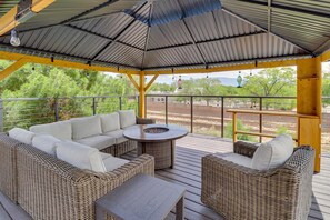 A covered outdoor seating area with wicker furniture and a fire pit. - Heated Pool! Hot Tub! Volleyball court! 3-bedroom, 3-Bathroom Fabolous Home! (Albuquerque)