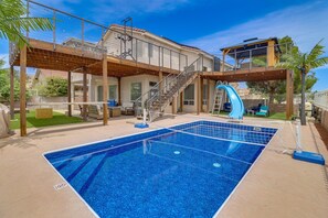 A swimming pool with a slide, a covered seating area, and a staircase leading to a second level. - Heated Pool! Hot Tub! Volleyball court! 3-bedroom, 3-Bathroom Fabolous Home! (Albuquerque)