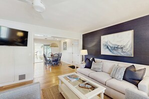 Ein Wohnzimmer mit einer Couch, einem Couchtisch und Kunstwerken an der Wand.