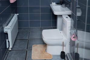 A bathroom with a toilet, sink, and radiator. - Castel Unghern (Ivancea)