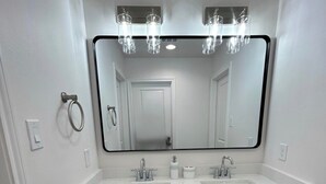 A bathroom with two sinks, a large mirror, and a towel ring. - Phenomenal 3-bedroom townhome with AC in Houston (Houston)