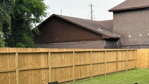 A patio with four black chairs and a table, surrounded by a wooden fence and a grassy lawn. - Phenomenal 3-bedroom townhome with AC in Houston (Houston)