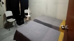 A small room with a bed, a chair, and a table. - Casa Paisa Planta Alta (Linares)