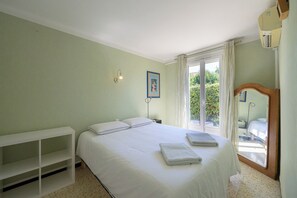 A bedroom with a bed, a nightstand, a shelf, a window with curtains, and a mirror. - Le Massillargue - AC - Wifi - Terrasse (Avignon)