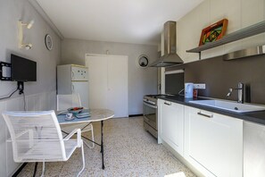 A compact kitchen with a dining area, a refrigerator, a stove, and a sink. - Le Massillargue - AC - Wifi - Terrasse (Avignon)