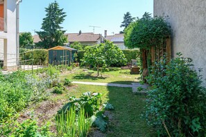 A garden with a variety of plants and a small wooden structure. - Le Massillargue - AC - Wifi - Terrasse (Avignon)