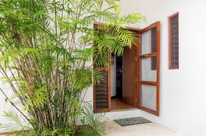 Una porta con stipite in legno e pannelli di vetro, che dà accesso a un ambiente interno.