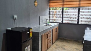 A kitchen with a built-in refrigerator, a sink, wooden cabinets, and a window with blinds. - Lux, Spacious, apt, close 2 the beach and Airport. (Greater Accra Region)