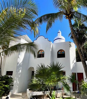A white building with arched windows and a dome, surrounded by palm trees. - Dazzling Beachfront Villa, Pool, 3 king bedrooms (Q.R.)
