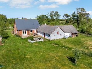 A large house with a sloped roof, a brick exterior, and a white interior.