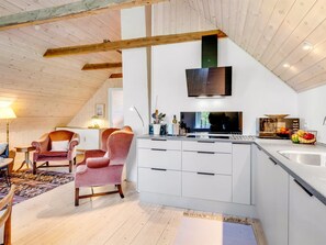 A modern kitchen with white cabinets, a built-in oven, and a microwave.
