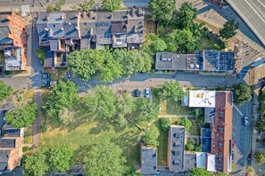 Ett flygbildsbild av ett bostadsområde med flera byggnader, träd och en väg.