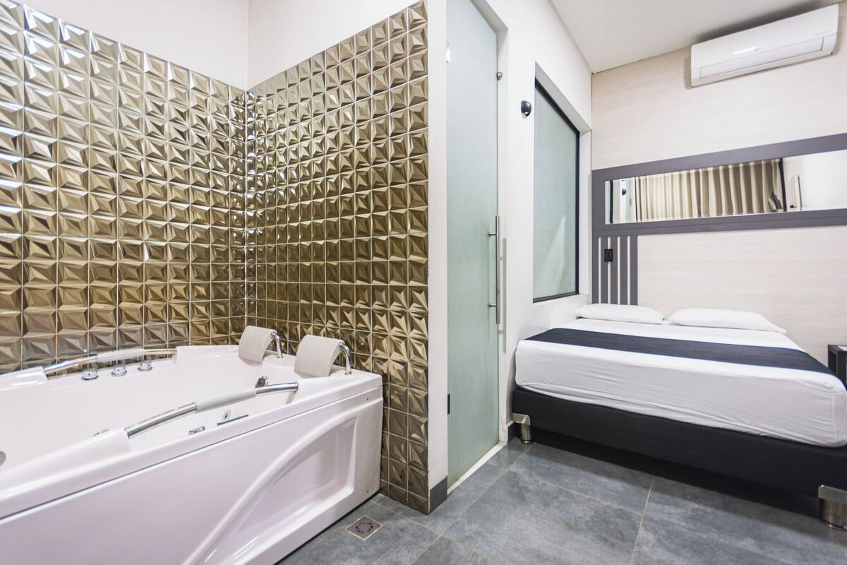 Un baño moderno con bañera, ducha, inodoro y lavamanos.