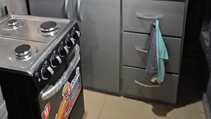 A compact kitchen with a gas stove, a microwave, and grey cabinets. - A beautiful relaxation, 10 mins to beach and 30 mins from the airport (Greater Accra Region)