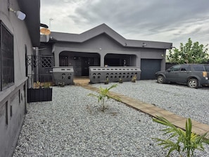 A modern building with a grey facade, a covered entrance, and a gravel driveway. - A beautiful relaxation, 10 mins to beach and 30 mins from the airport (Greater Accra Region)