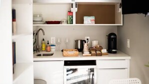 A compact kitchen with a dishwasher, sink, and various kitchen items. - Studio Style Single Room Cottage...Luca's Place (Phoenix)