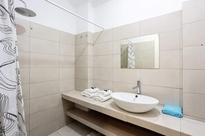 A bathroom with a shower, a sink, a mirror, and a towel rack. - Santorini s Welcoming Getaway - Blissful Homely (Santorini)