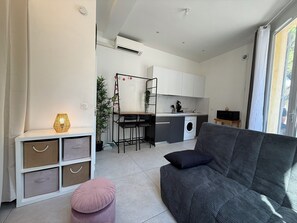 Un apartament modern amb zona de estar, bugaderia i rentadora.