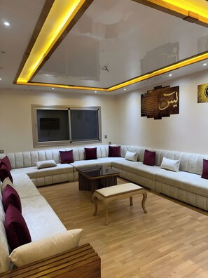 Ein modernes Wohnzimmer mit einer Eckcouch, einem Couchtisch und einer Holzbank.