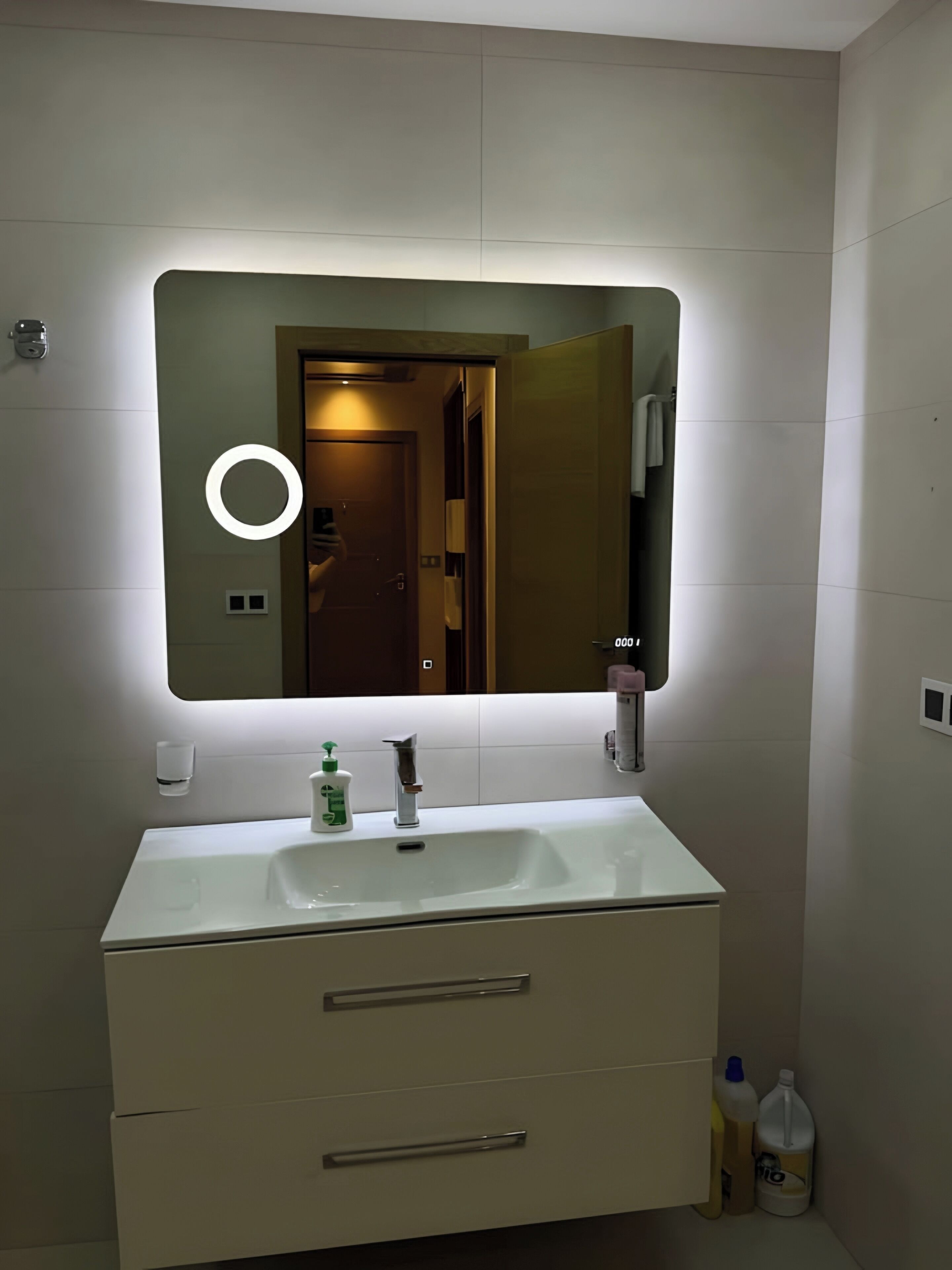 Un baño con un espejo grande, un lavamanos y dos cajones.