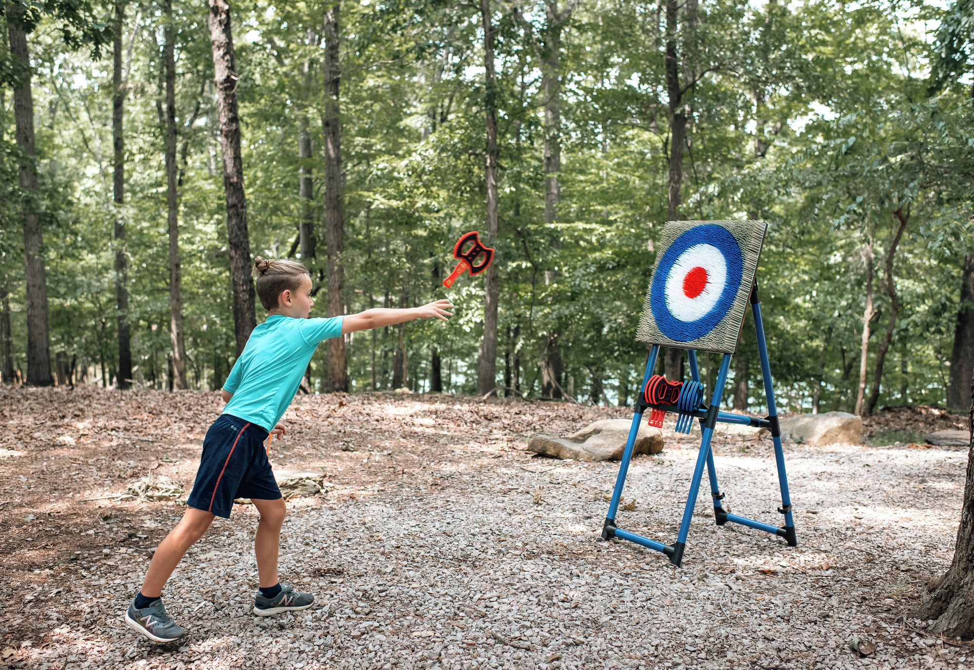 A person aiming at a target in a forested area.