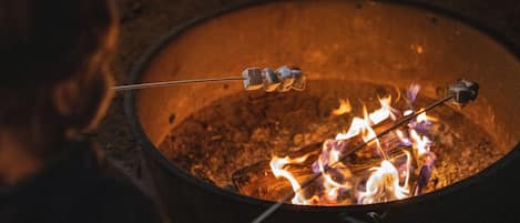 Een kampvuur met marshmallows die geroosterd worden.
