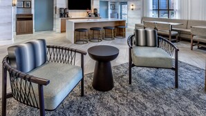 A spacious lobby with a bar area, seating arrangements, and a large window providing natural light. - King Studio w/ Kitchen | Hot Breakfast + Pool (Denver)