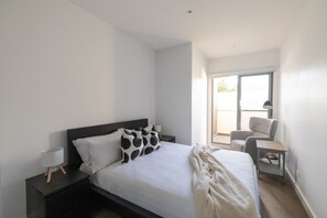 A modern bedroom with a bed, a chair, a desk, and a window. - Quiet Murrumbeena Escape Near Chadstone & CBD (Murrumbeena)