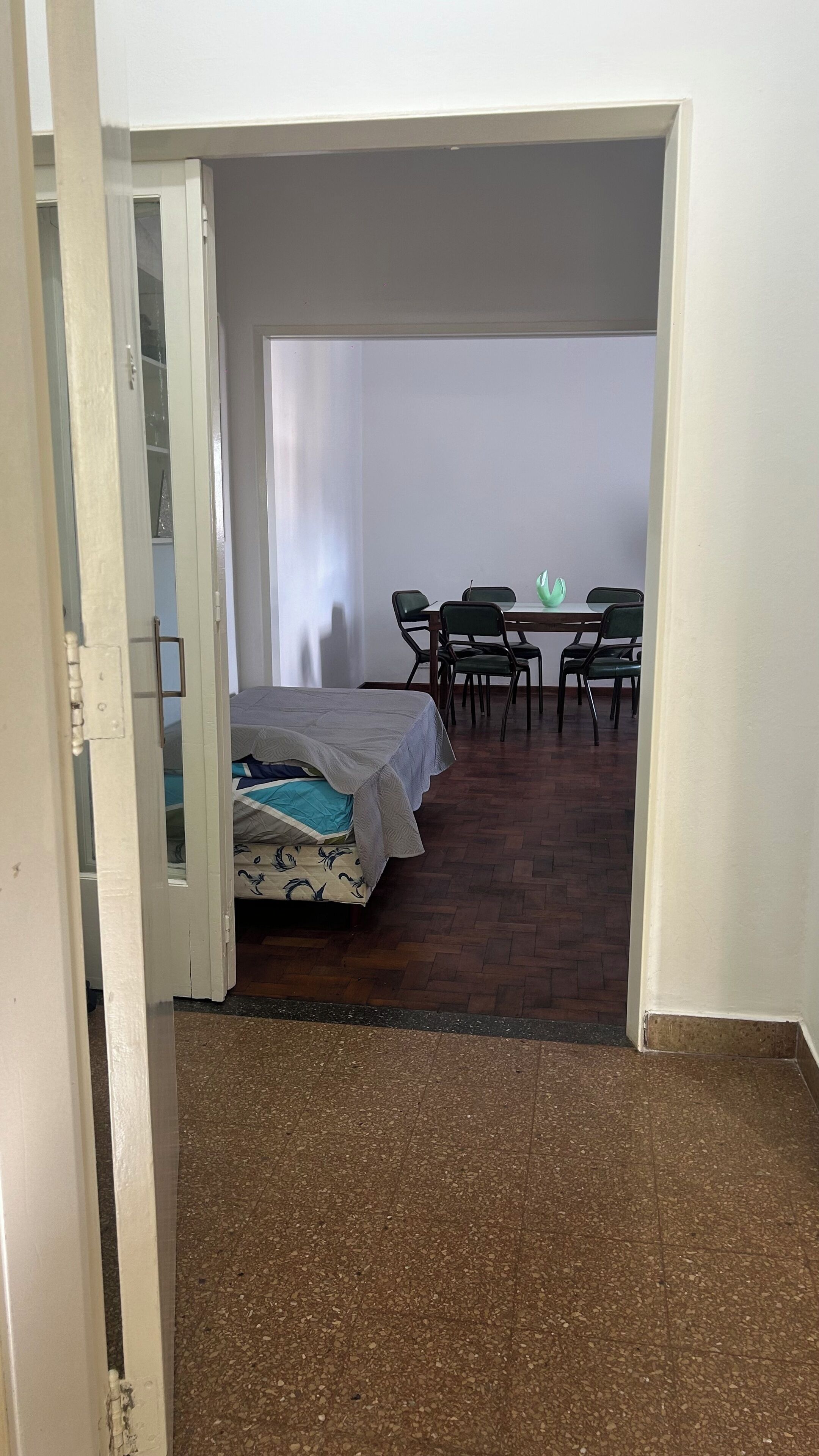 Una habitación con una cama, una mesa y sillas.