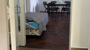 Una habitació amb un llit, una taula i cadires.
