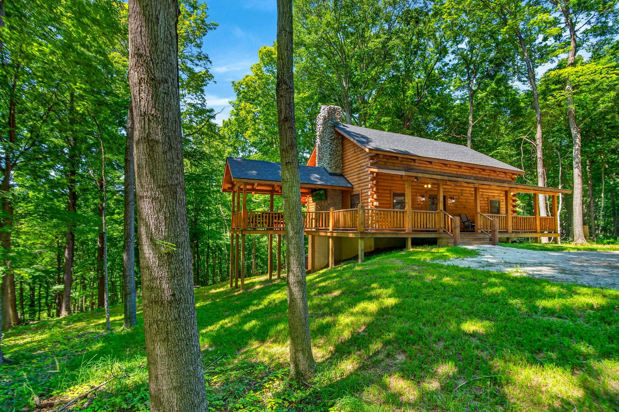 Eine Holzhütte mit Veranda, umgeben von einem Wald.