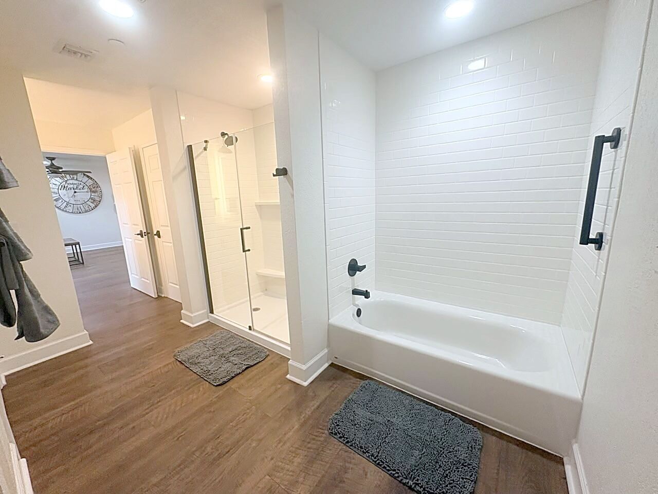 A modern bathroom with a bathtub, a shower, and a glass-enclosed shower area.