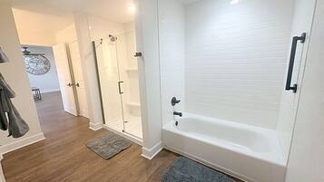 A modern bathroom with a bathtub, a shower, and a glass-enclosed shower area.