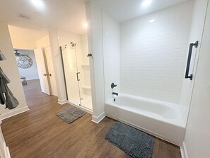 Ein modernes Badezimmer mit Badewanne, Dusche und einer Glaskabine für die Dusche.