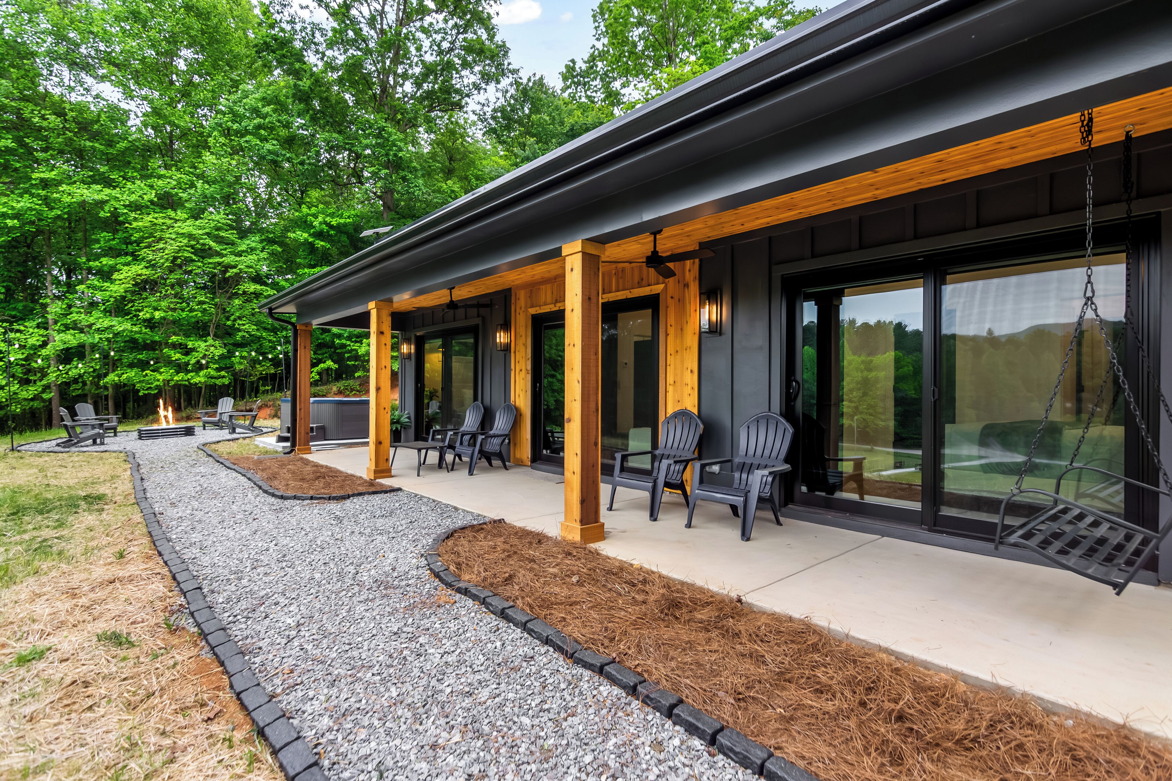 Een modern gebouw met een overdekte patio, buiten zitplaatsen en een vuurplaats.
