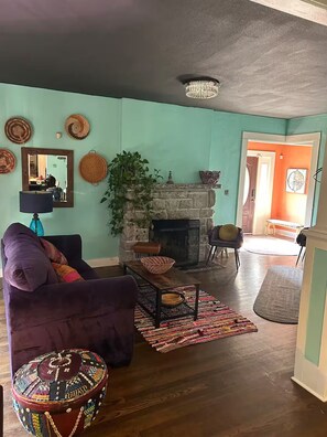 Ein Wohnzimmer mit Kamin, einer Couch, einem Couchtisch und einem Teppich.