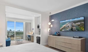 A modern hotel room with a large bed, a dining area, a kitchen, and a balcony with a city view. - FontaineBleau |Mid-Floor w/ City, Bay & Ocean View (Miami Beach)