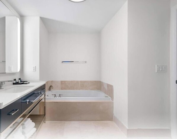 A modern bathroom with a bathtub, a vanity with a mirror, and a towel rack. - Fontainebleau |Mid-Floor w/ City, Bay & Ocean View (Miami Beach)