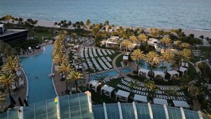 Ein Resort mit Pool, Palmen und Meerblick.