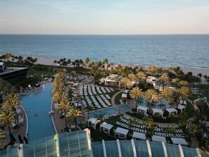 Ein Resort mit Pool, Palmen und Meerblick.