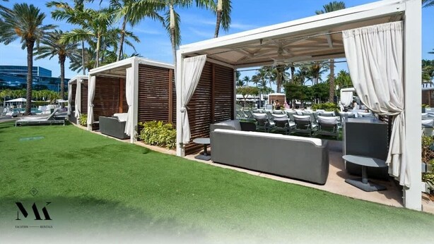 Resort com áreas de estar ao ar livre, palmeiras e piscina.