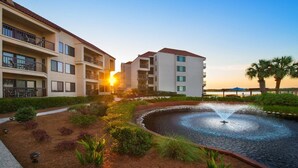 A hotel with a courtyard featuring a fountain, surrounded by well-maintained landscaping and a view of the sunset. - Hilton Head Island Escape with Spacious 2BR Villa Near the Beach (Hilton Head Island)