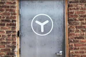Una puerta con un símbolo circular y un picaporte de metal.