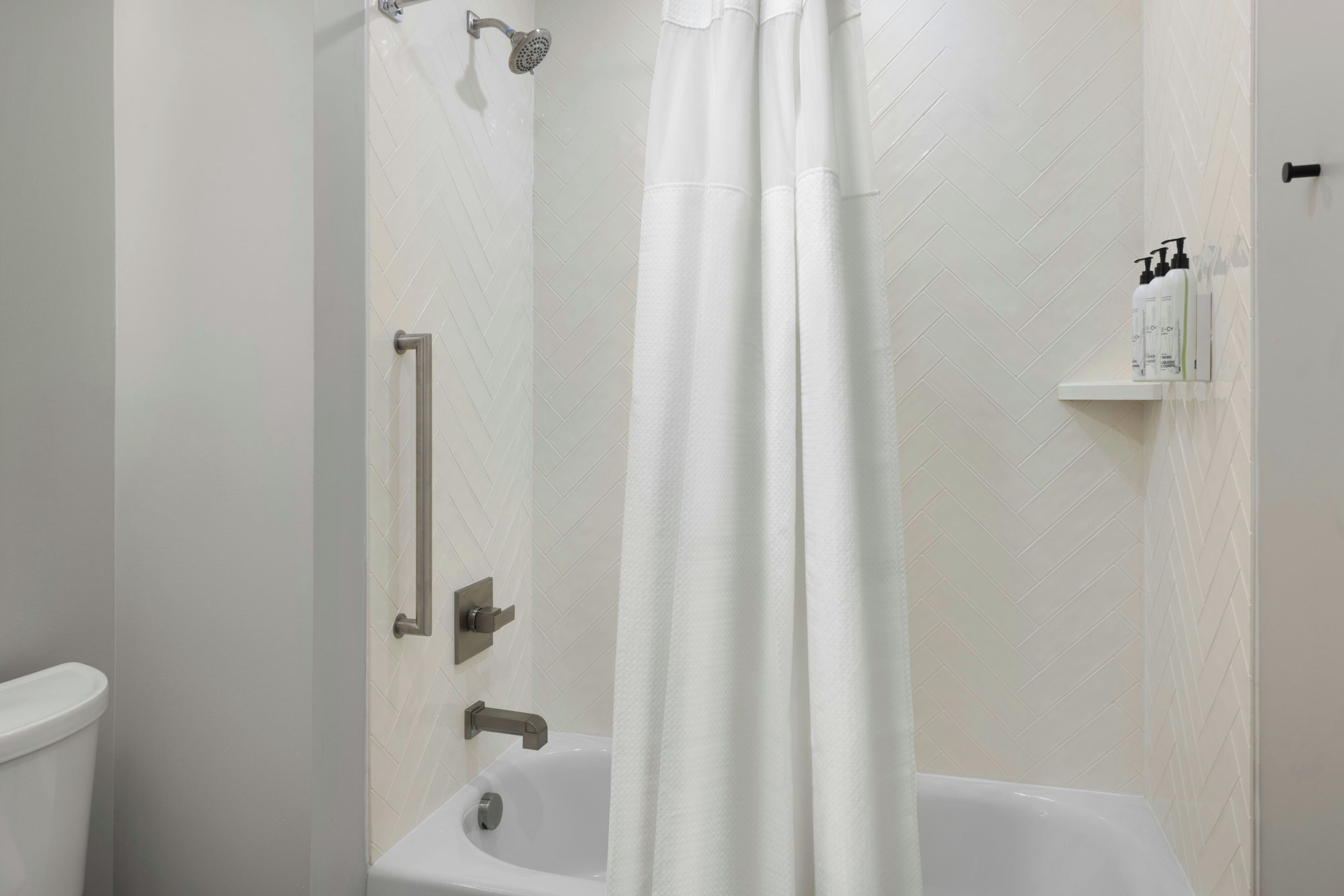 A bathroom with a shower, a toilet, and a sink.