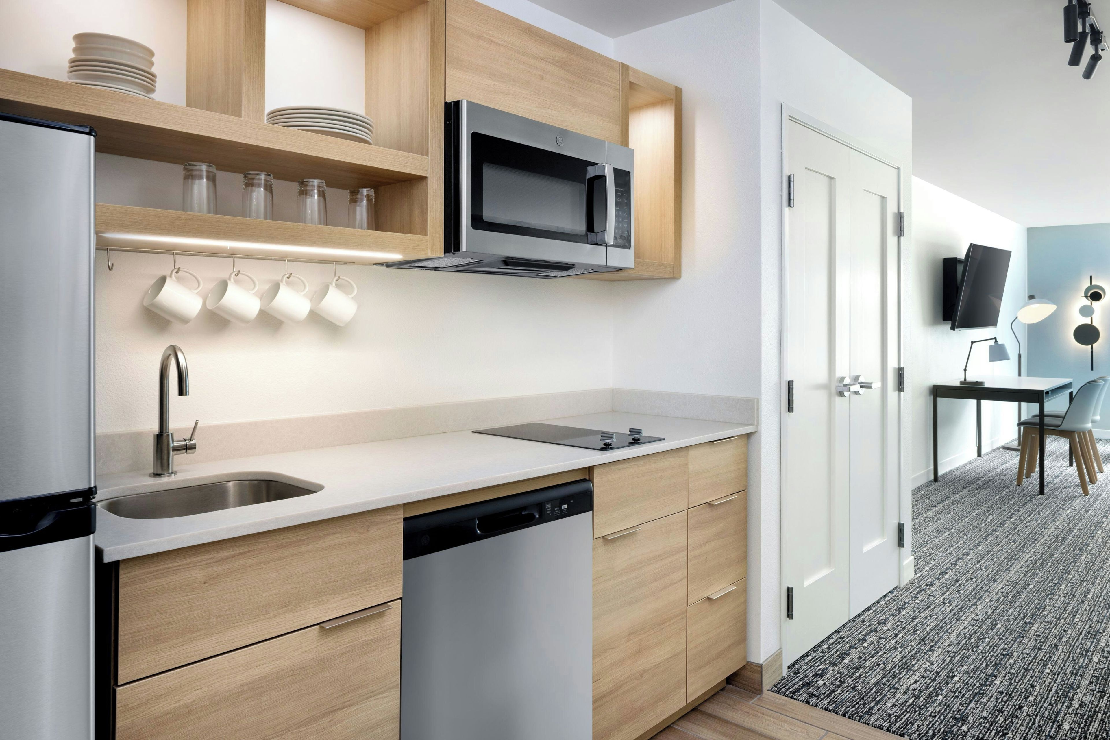 A modern kitchen with a built-in dishwasher, a microwave, and a sink.