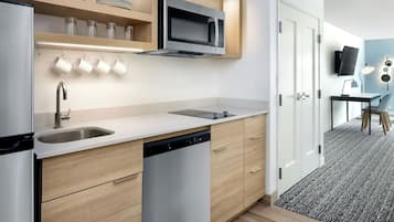 A modern kitchen with a built-in dishwasher, a microwave, and a sink.