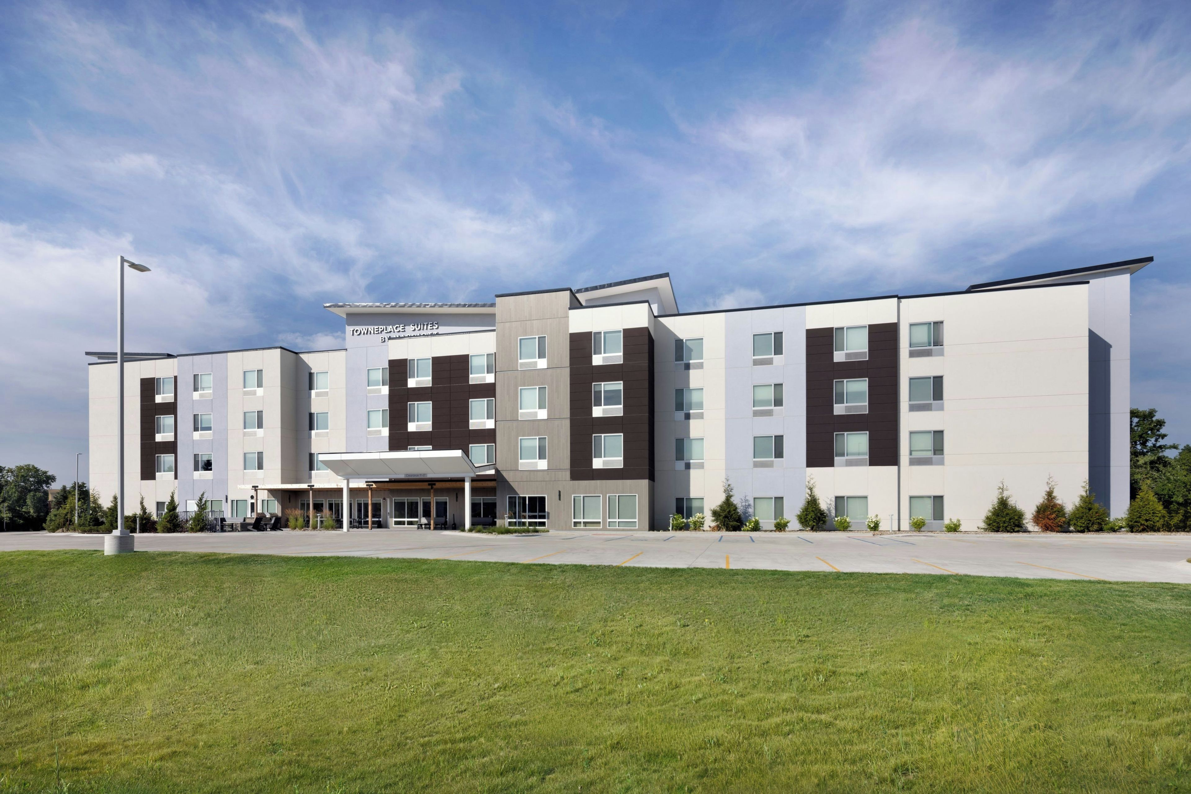 A modern hotel with a central courtyard, multiple floors, and a covered entrance.
